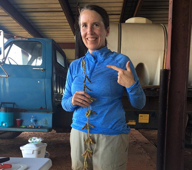 Anne Alerding shows off a soy plant during one of the team's excursions into the field.